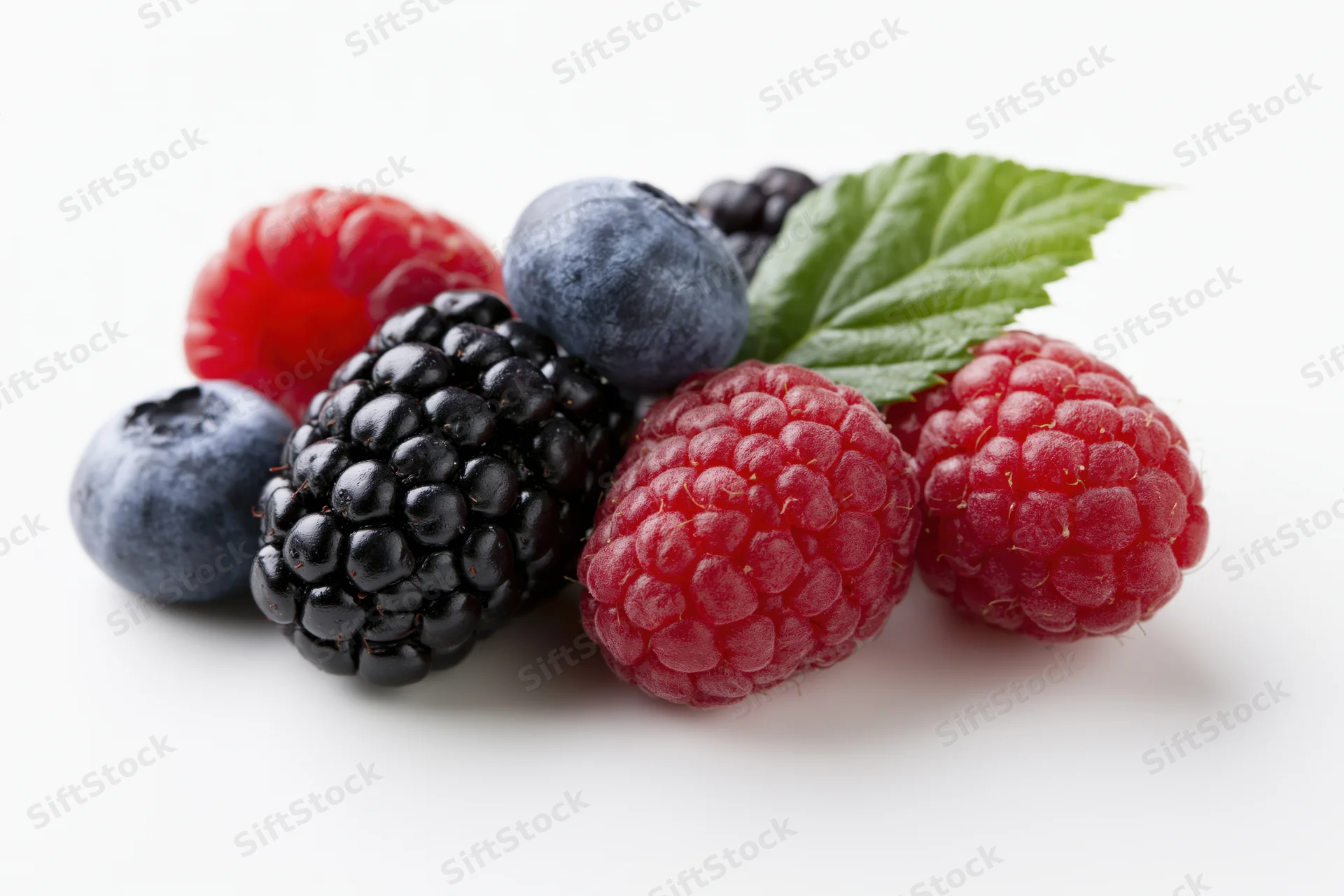 Cluster of fresh mixed berries including blackberries, raspberries and blueberries on white background