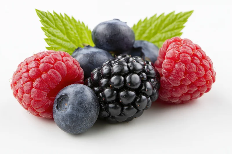 Mixed fresh berries including raspberry blueberry and blackberry with green leaves arranged on white background