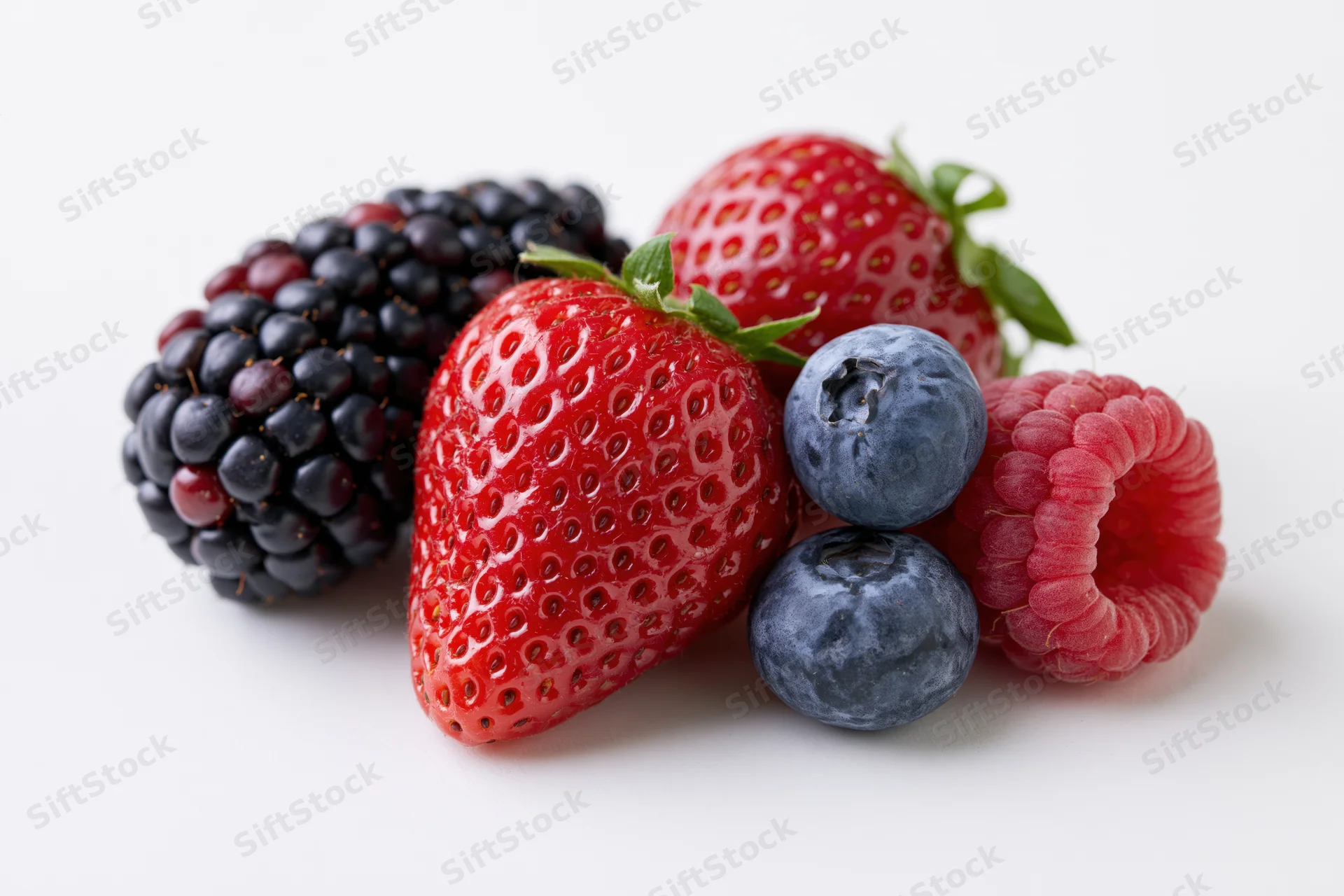 Cluster of fresh strawberries, blackberries, raspberries and blueberries on white background
