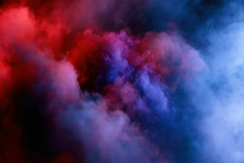 Swirling red and blue smoke filling the frame against a dark background