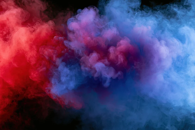 Swirling red and blue smoke blending into purple against black background
