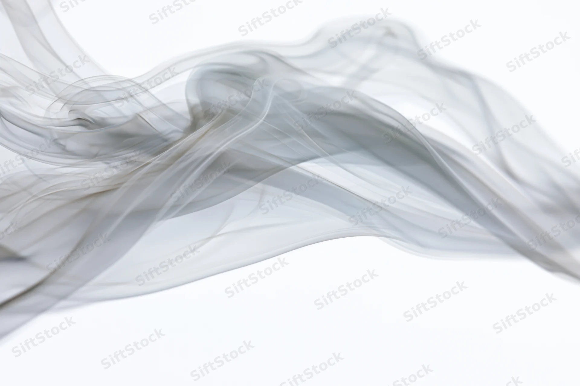 Thin gray smoke drifting and curling against a white background