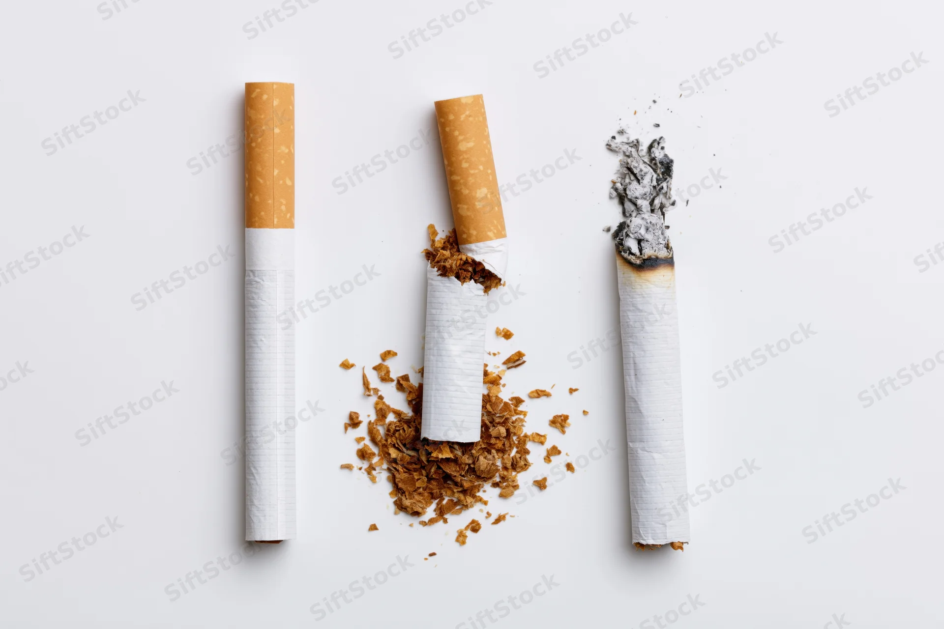 Three cigarettes arranged vertically on white background, one broken and crushed, one with ash, symbolizing smoking cessation