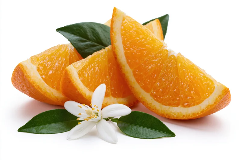 Three fresh orange wedges arranged with a white blossom and green leaves on a white background