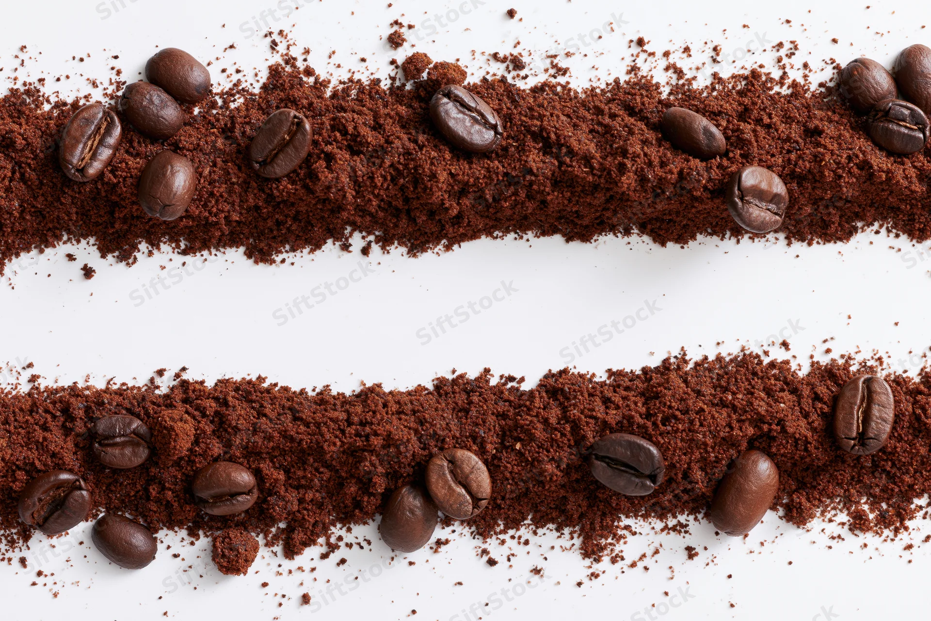 Two horizontal strips of ground coffee with whole beans scattered on white background