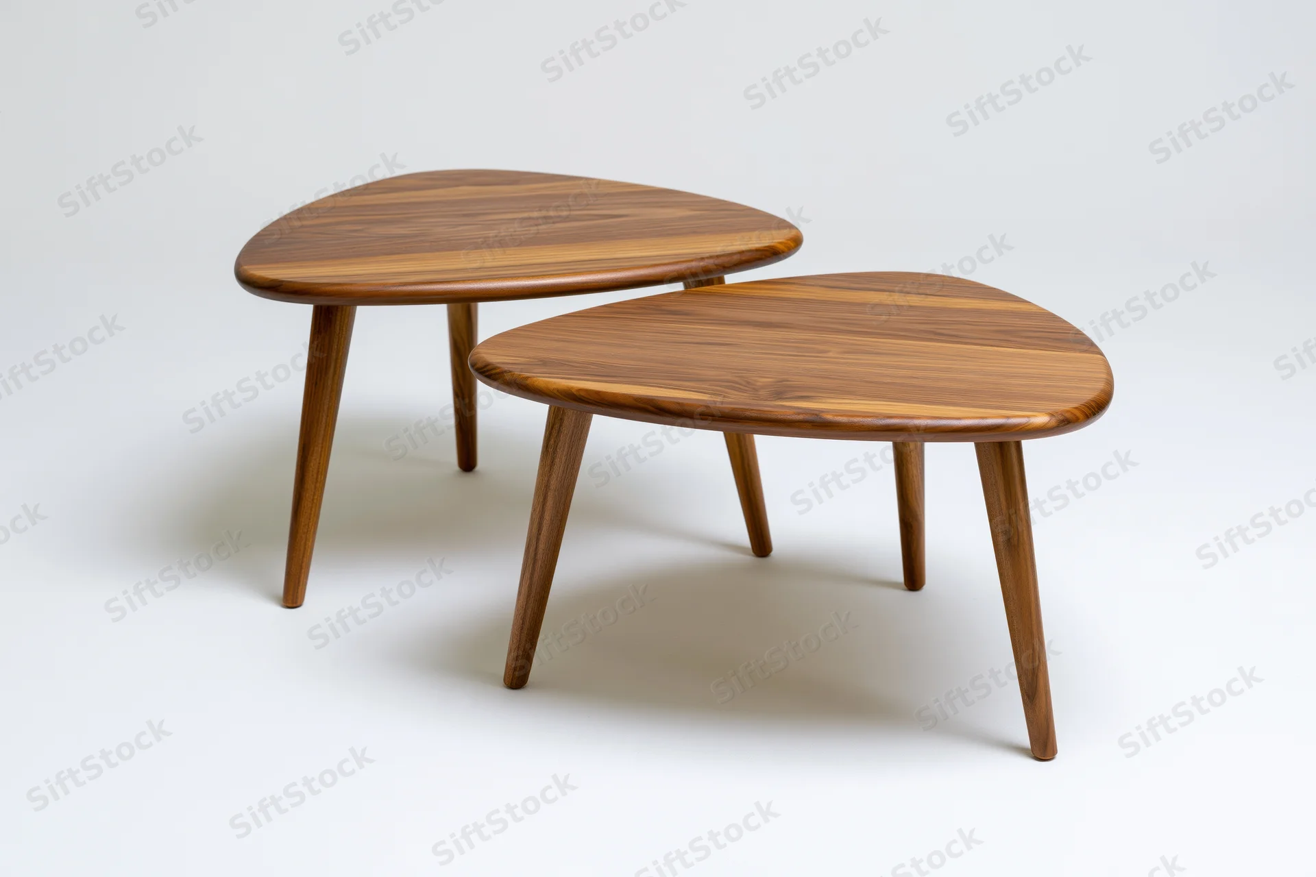 Two midcentury modern wooden nesting coffee tables on white background