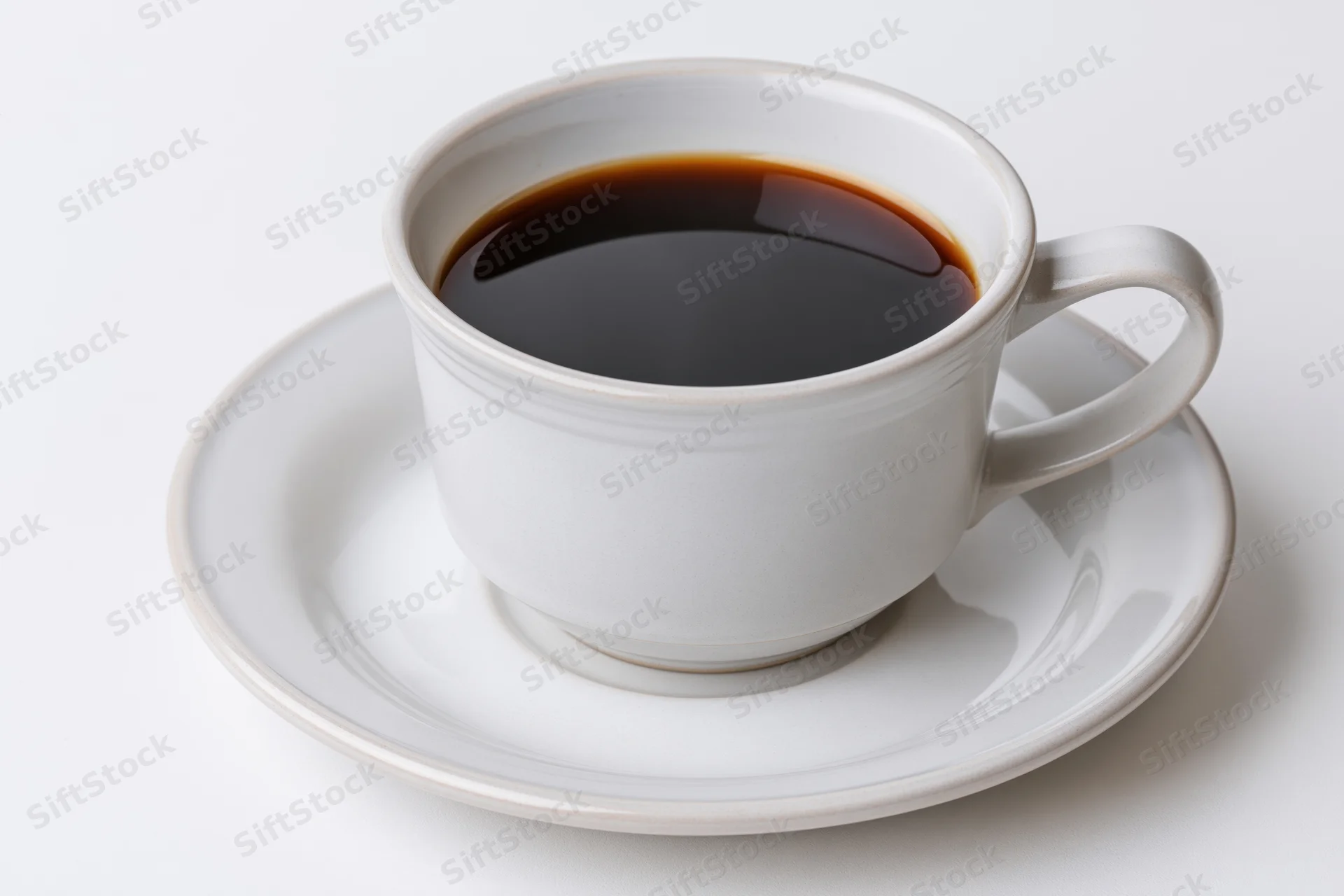 White ceramic coffee cup filled with black coffee on a matching saucer against a plain white background