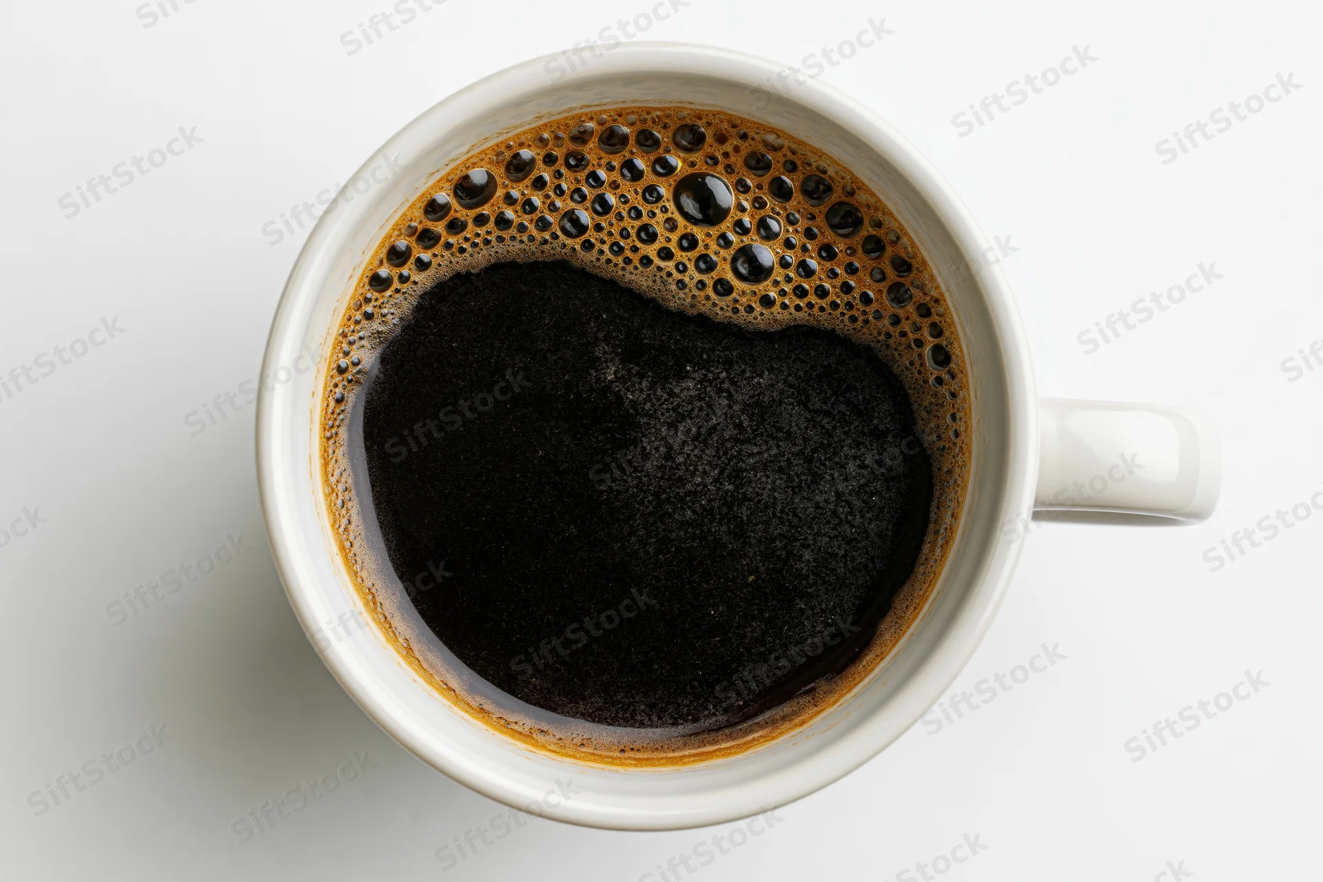 Overhead view of a white ceramic mug filled with black coffee on a plain white surface