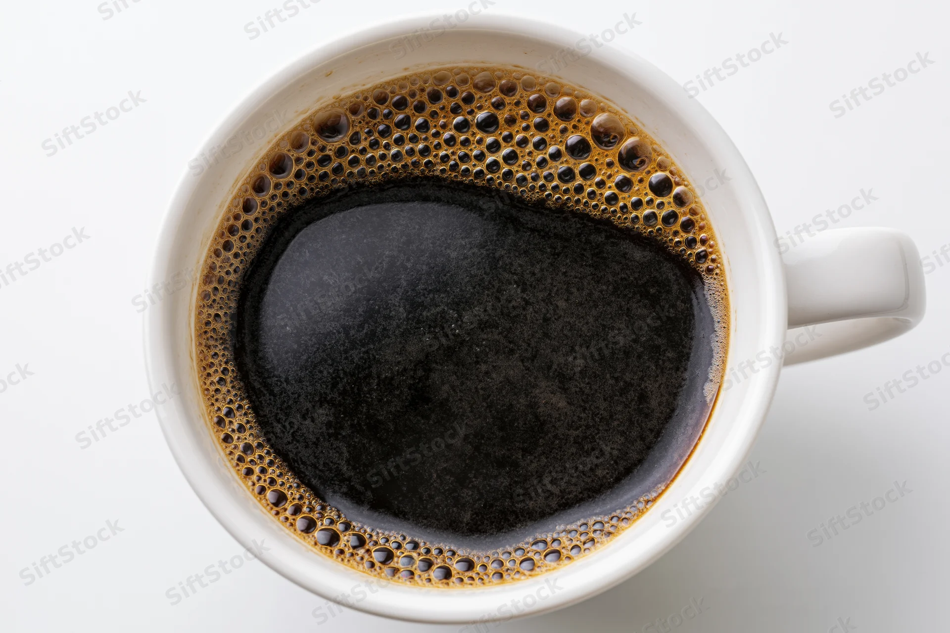 Top view of black coffee in a white ceramic mug on a plain white surface