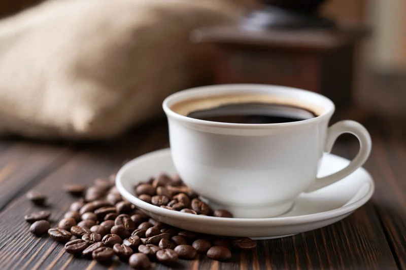 White ceramic cup of coffee with foam ring sitting on saucer