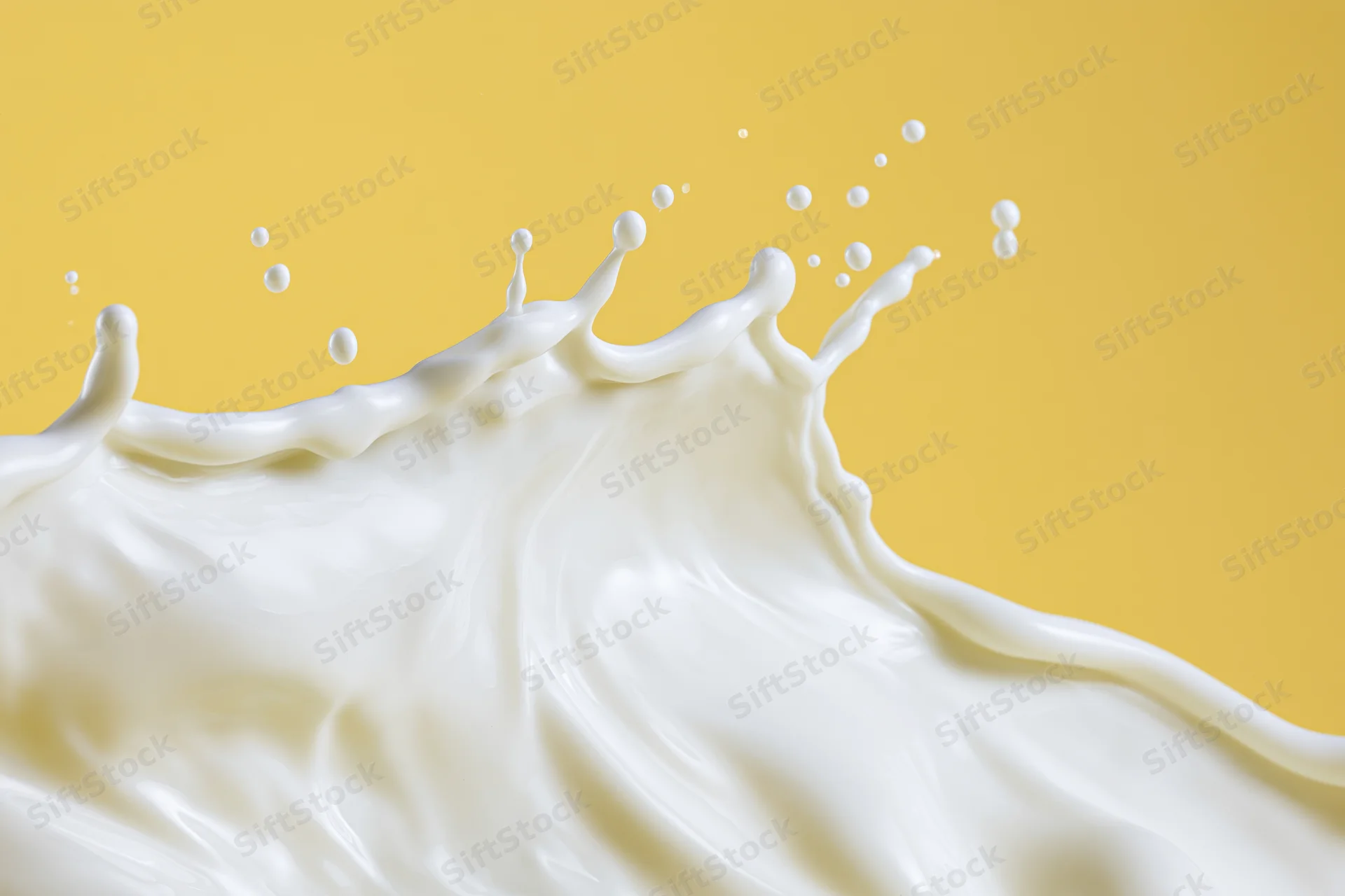 White milk splashing in a dynamic wave across the lower half against a yellow background