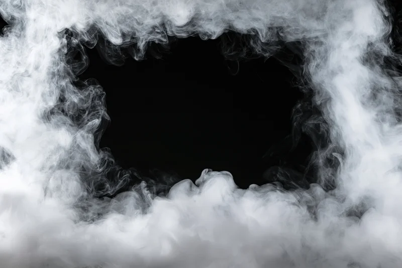 White smoke swirling to form a dark central opening against black background