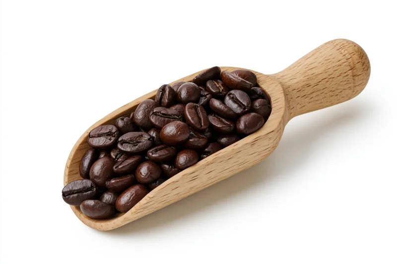 Wooden scoop filled with dark roasted coffee beans on white background