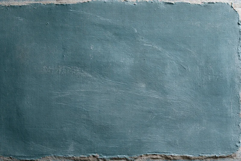 Worn teal-painted canvas surface filling the frame