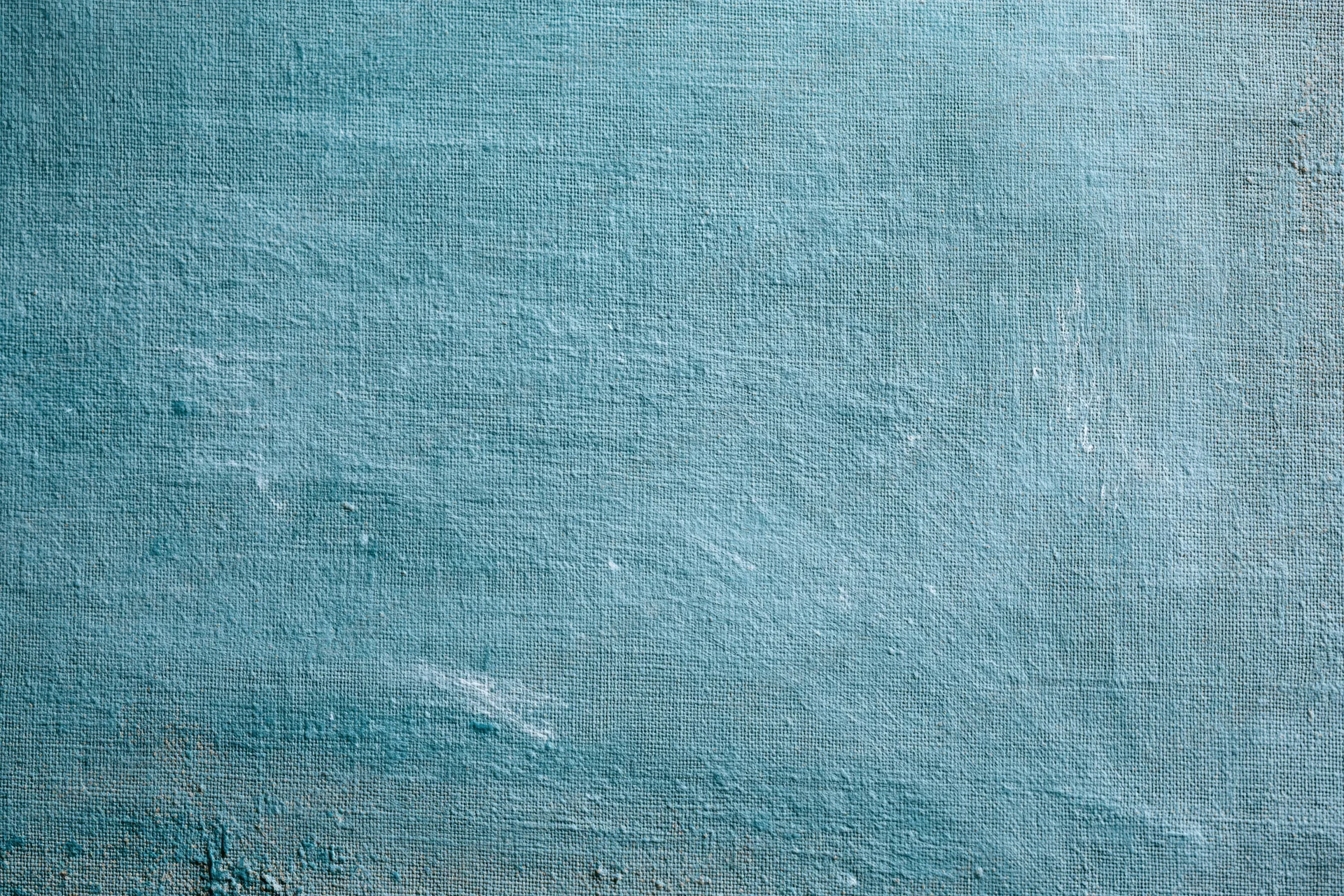 Worn teal-painted canvas surface filling the frame