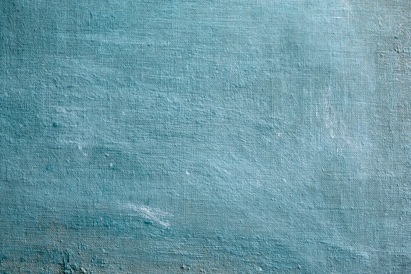 Worn teal-painted canvas surface filling the frame