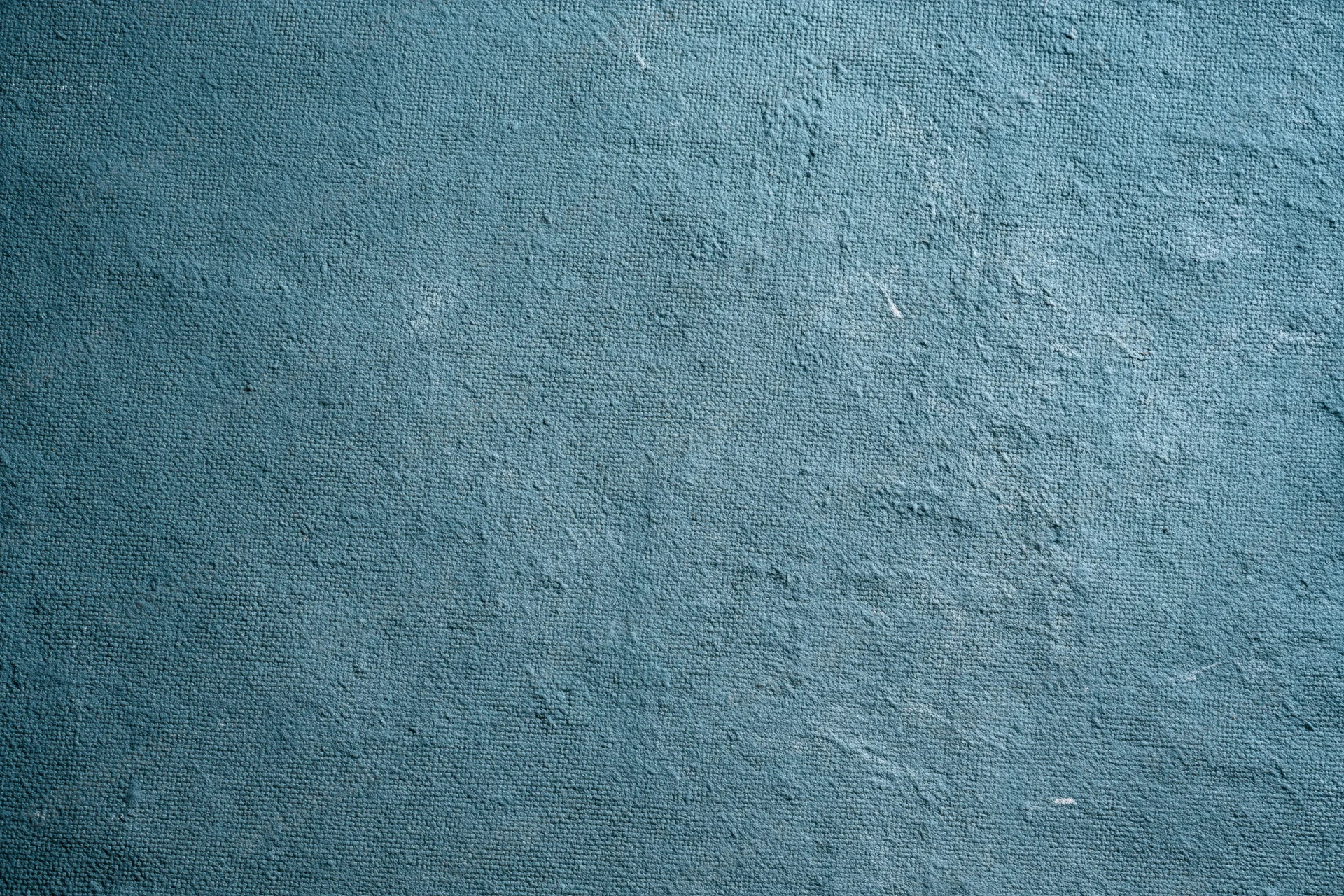 Worn teal-painted canvas surface filling the frame