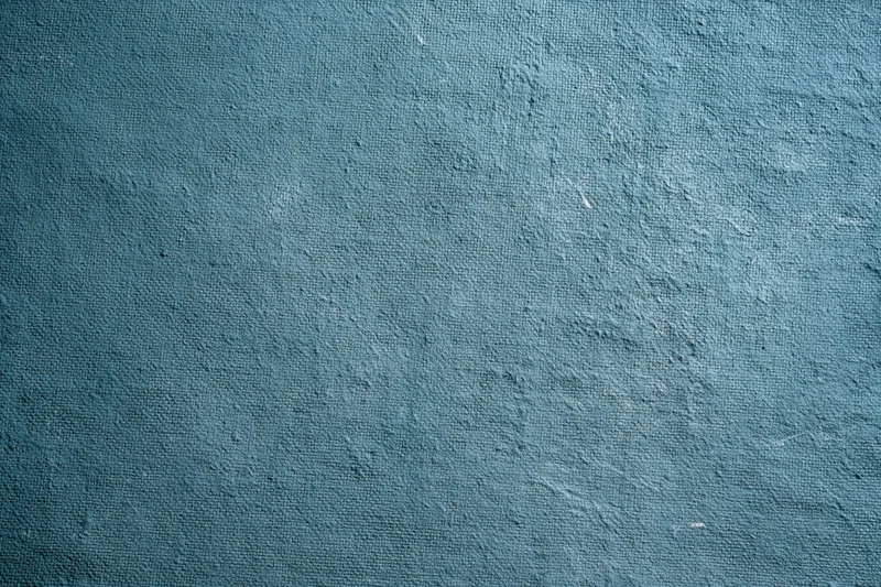 Worn teal-painted canvas surface filling the frame