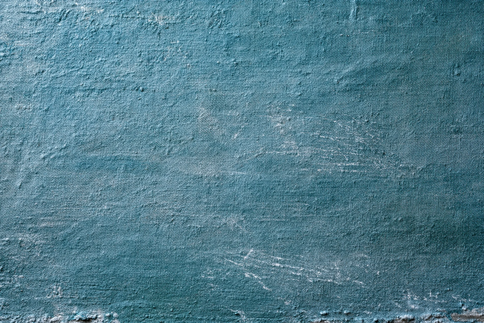 Worn teal-painted canvas surface filling the frame