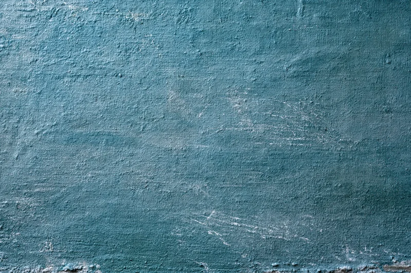Worn teal-painted canvas surface filling the frame