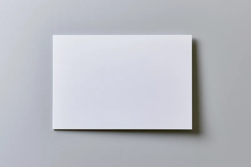 Blank white brochure lying flat on gray surface