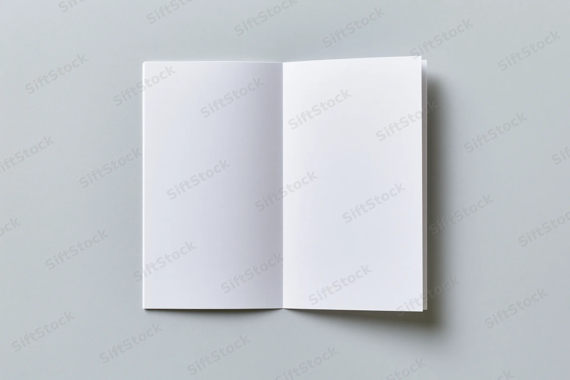 Open blank white brochure lying flat on gray surface with copyspace