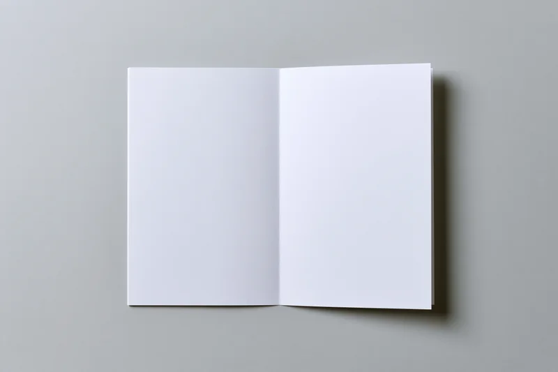Open blank white brochure lying flat on gray surface with copyspace