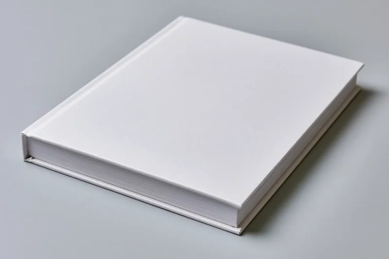 Blank white hardcover book lying flat on gray surface in landscape orientation