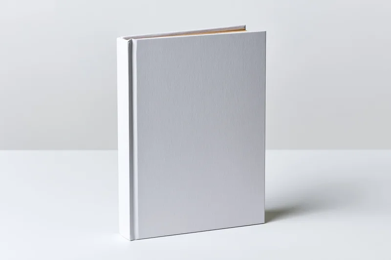 Blank white hardcover book standing upright on a white surface