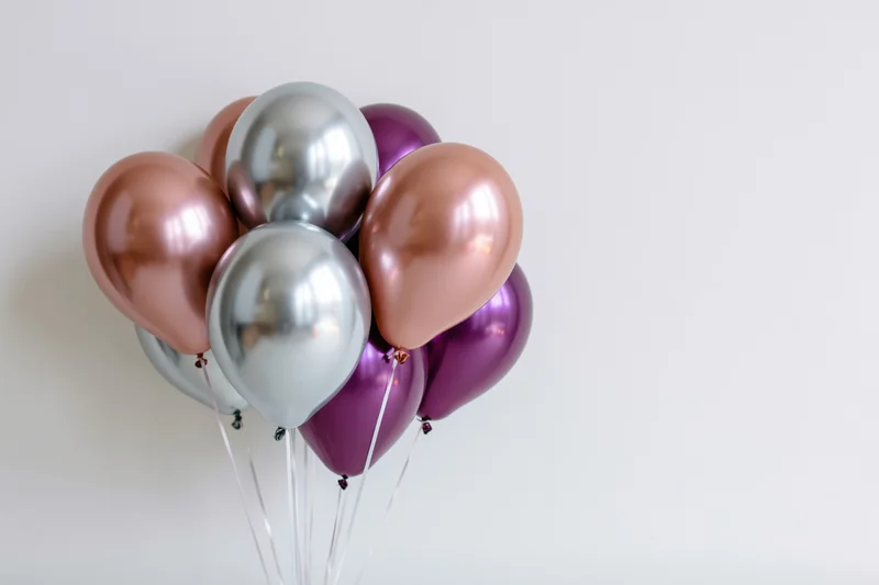 Metallic balloons clustered together against a white background with copyspace