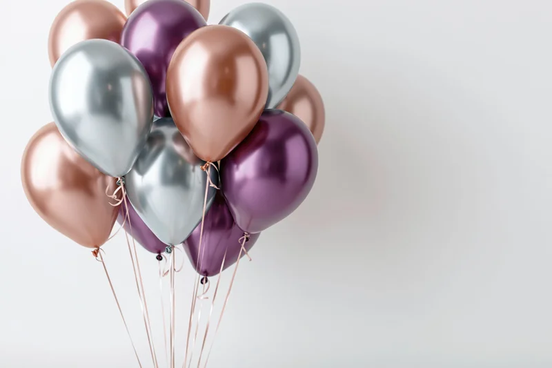 Metallic balloons clustered together against a white background with copyspace