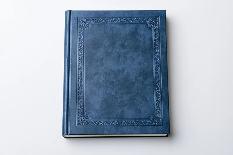Navy blue leather-bound book with embossed frame on white background