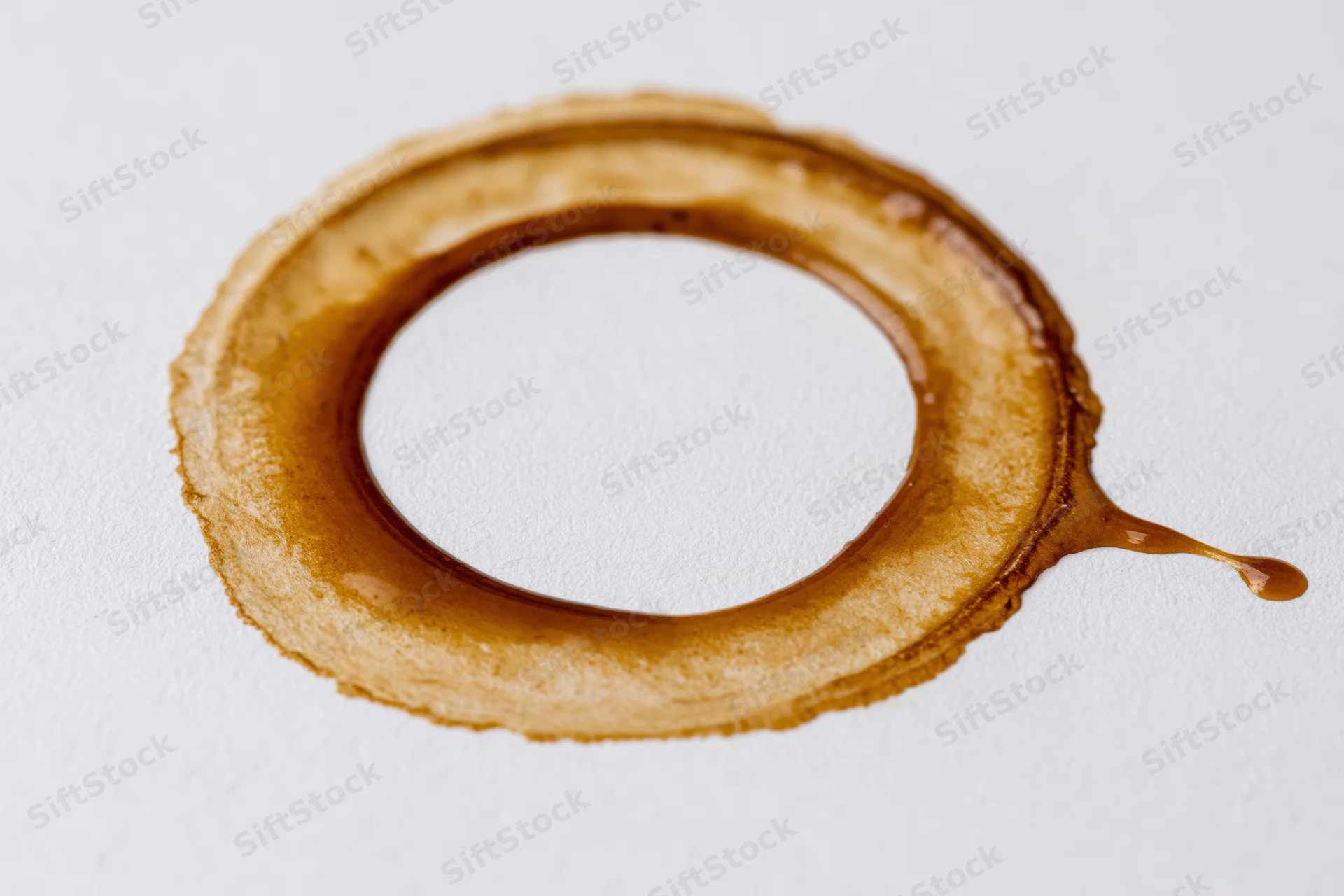 Dried coffee ring stain on a flat white surface