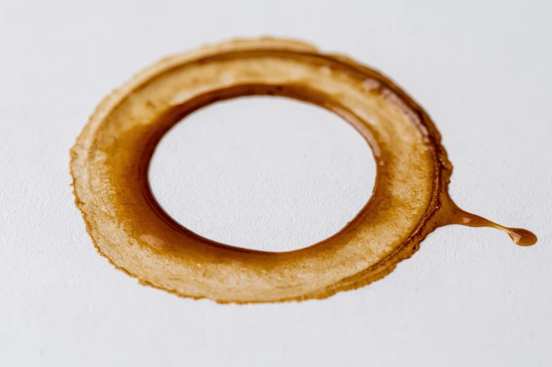 Dried coffee ring stain on a flat white surface