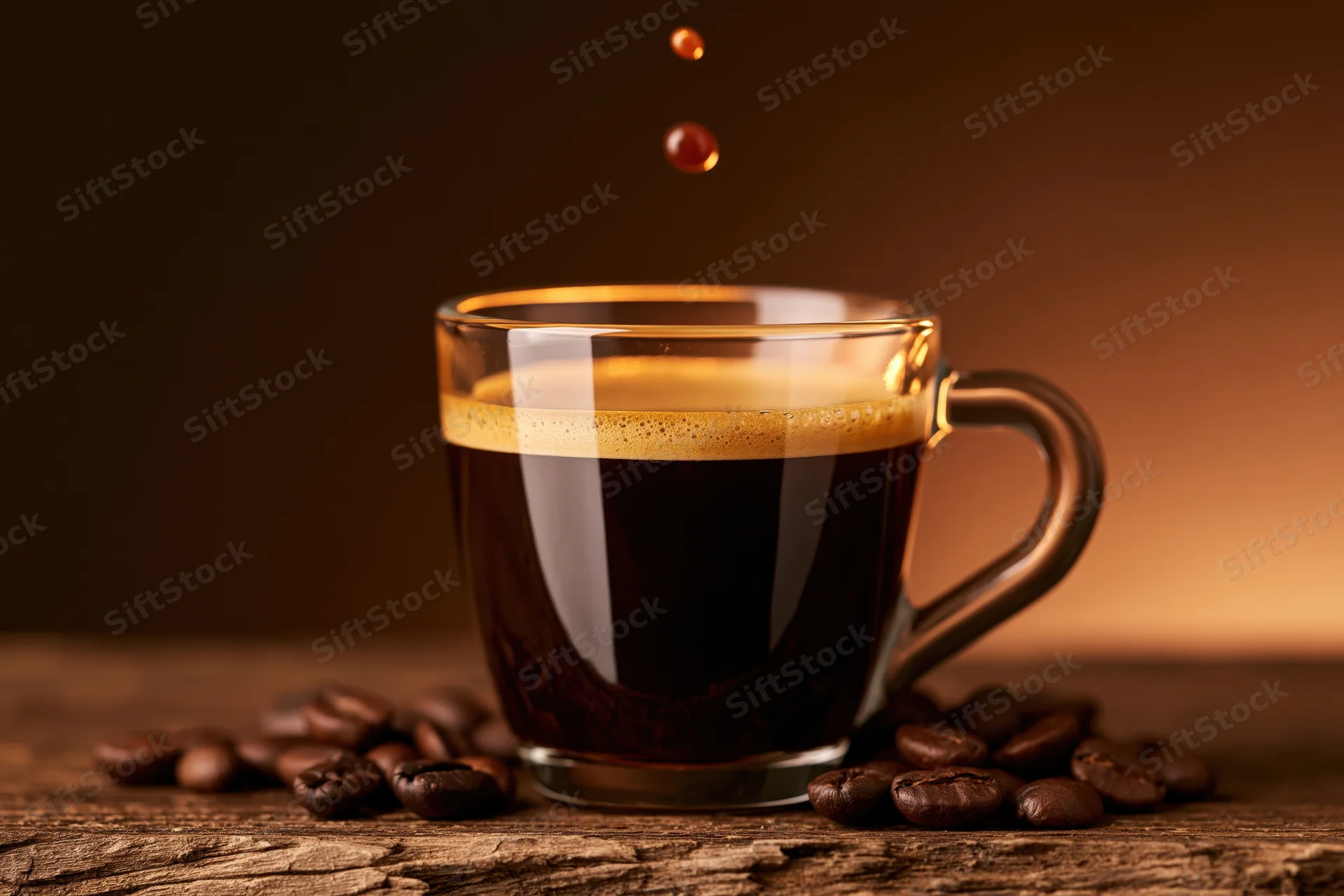 Glass espresso cup filled with dark coffee and crema on wooden table surrounded by roasted beans with falling droplets above