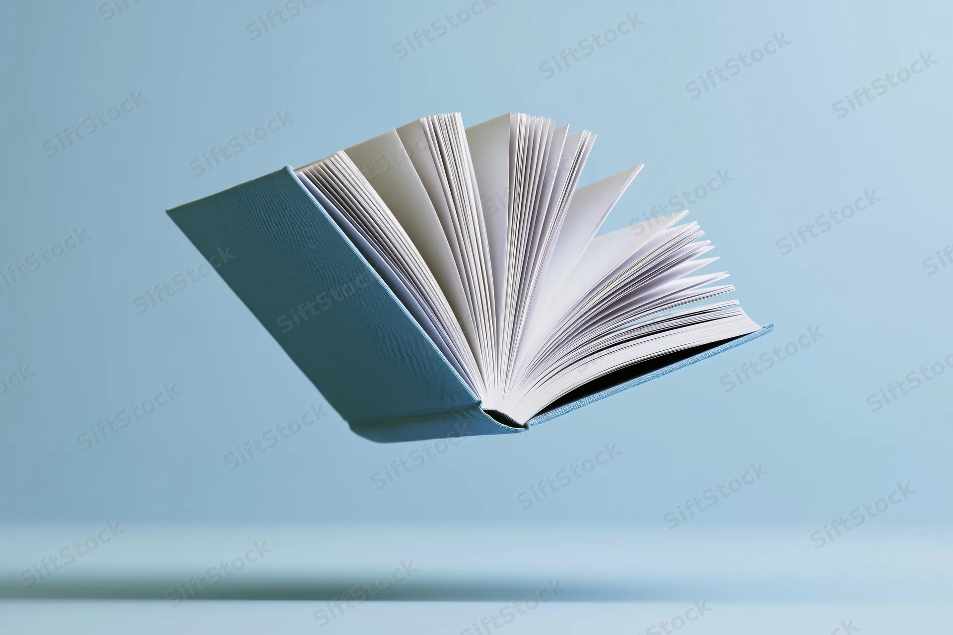Open hardcover book floating midair with pages fanned against a blue background