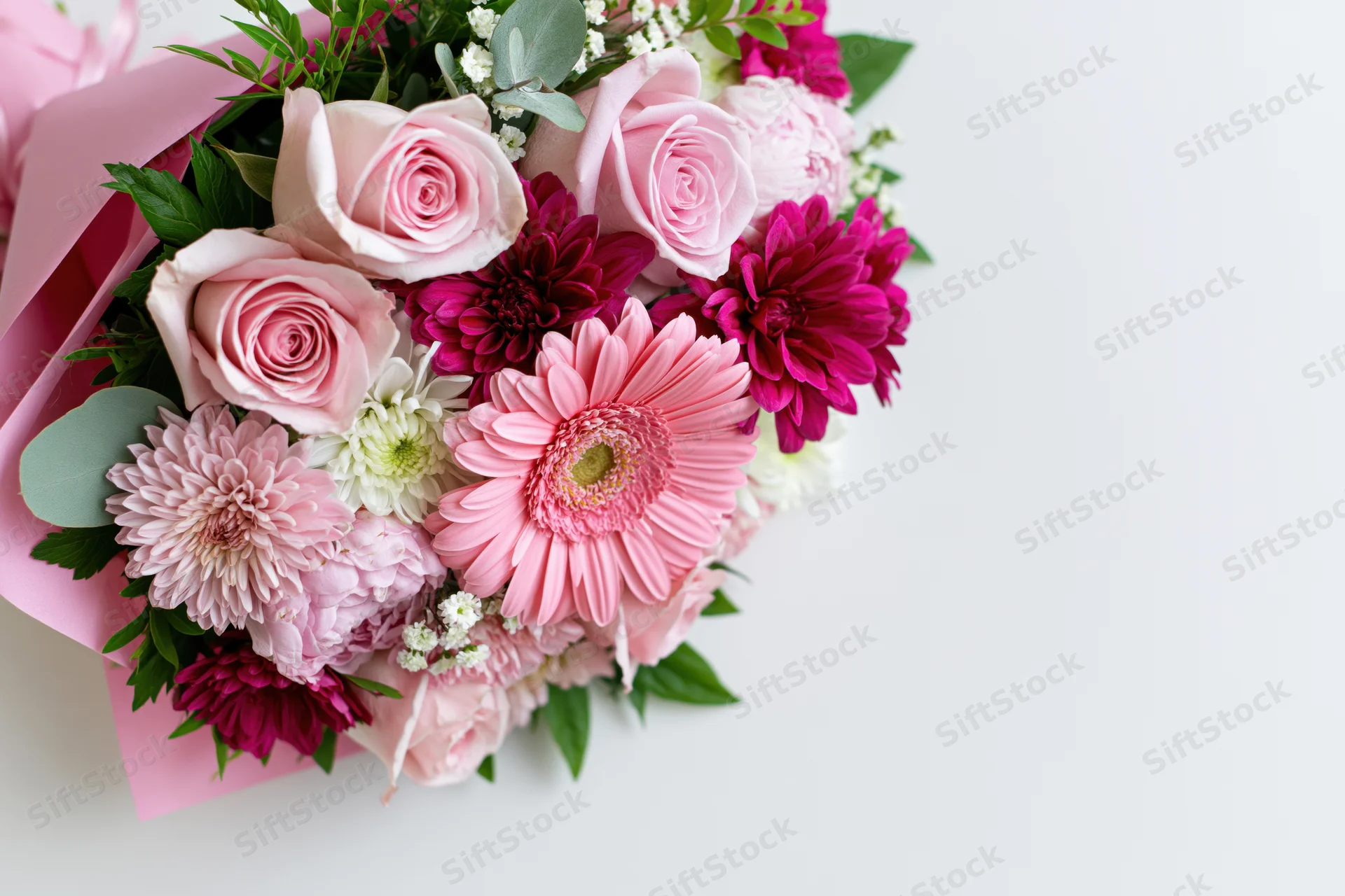 Mixed floral bouquet with pink roses and gerbera daisies on white background