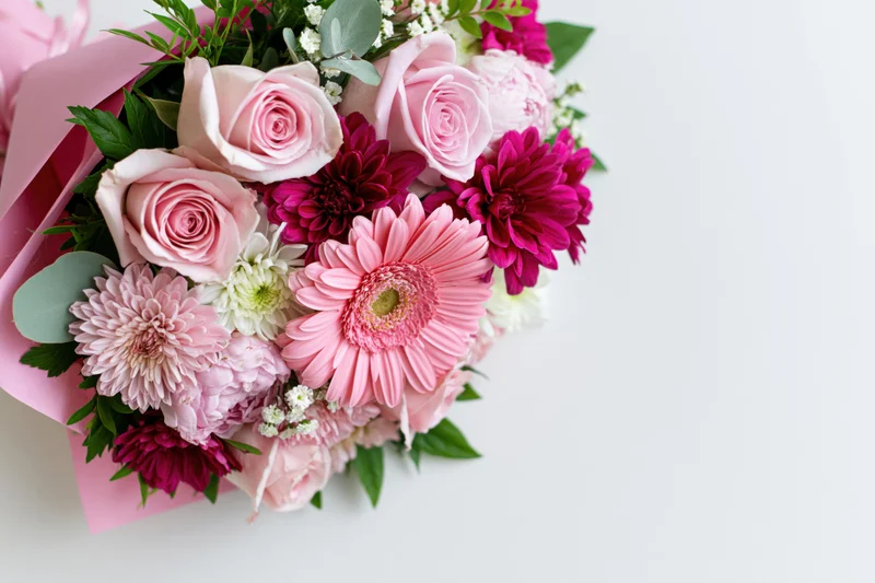 Mixed floral bouquet with pink roses and gerbera daisies on white background