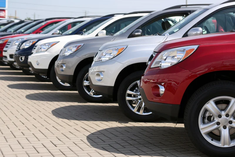 Row of suvs parked diagonally on paved dealership lot