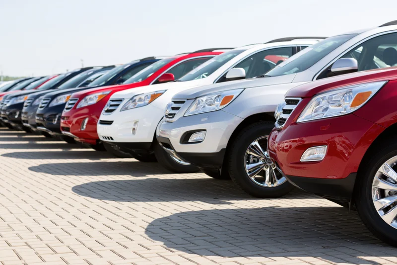 Row of suvs parked diagonally on paved dealership lot