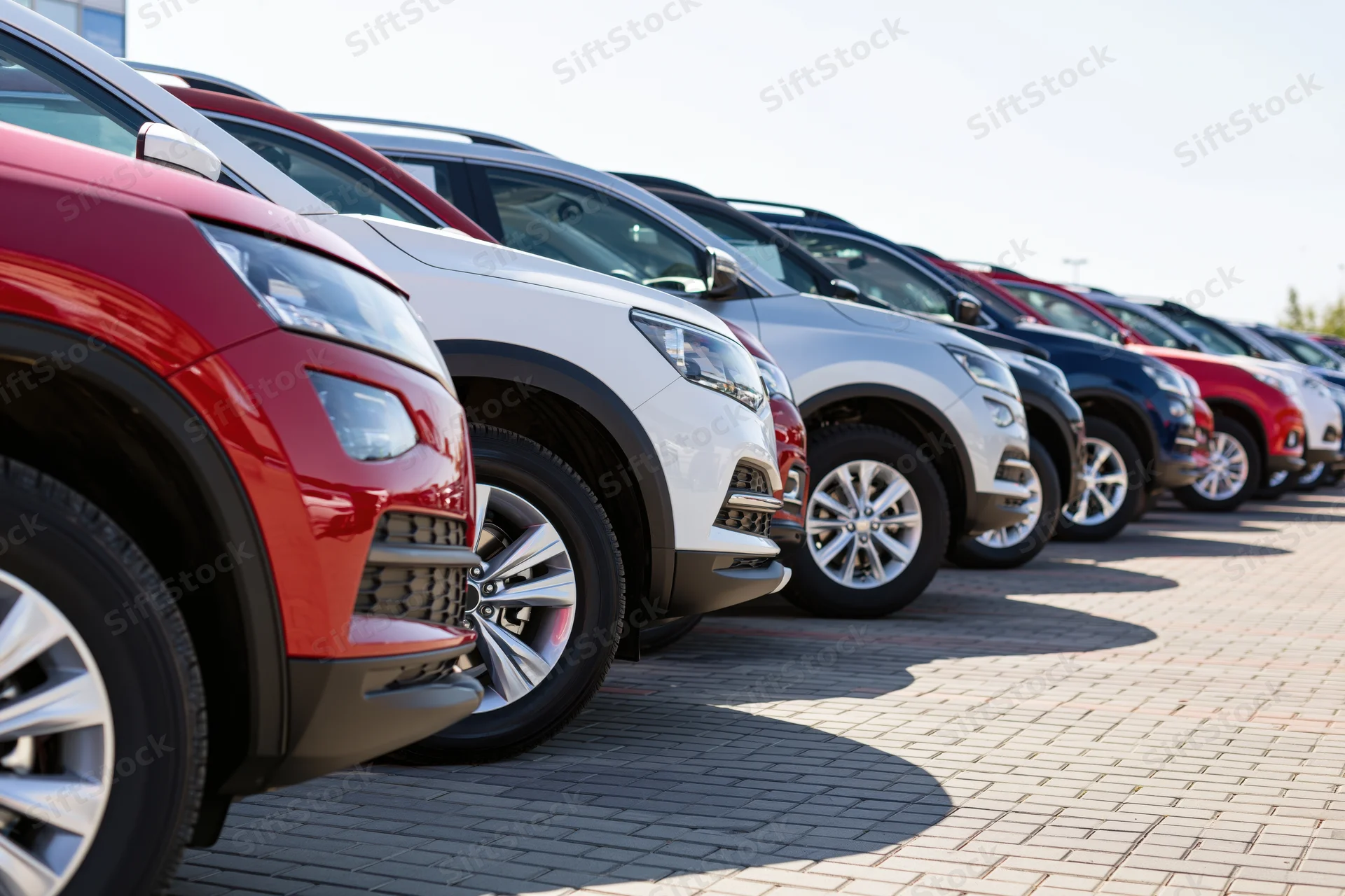 Row of suvs parked diagonally on paved dealership lot