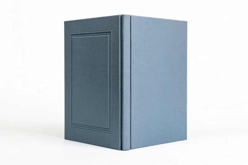 Blank hardcover book with muted slate-blue cloth binding on white background