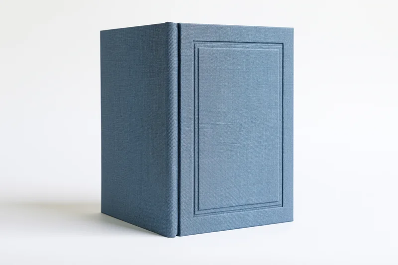 Single blank hardcover book with muted slate-blue cloth binding