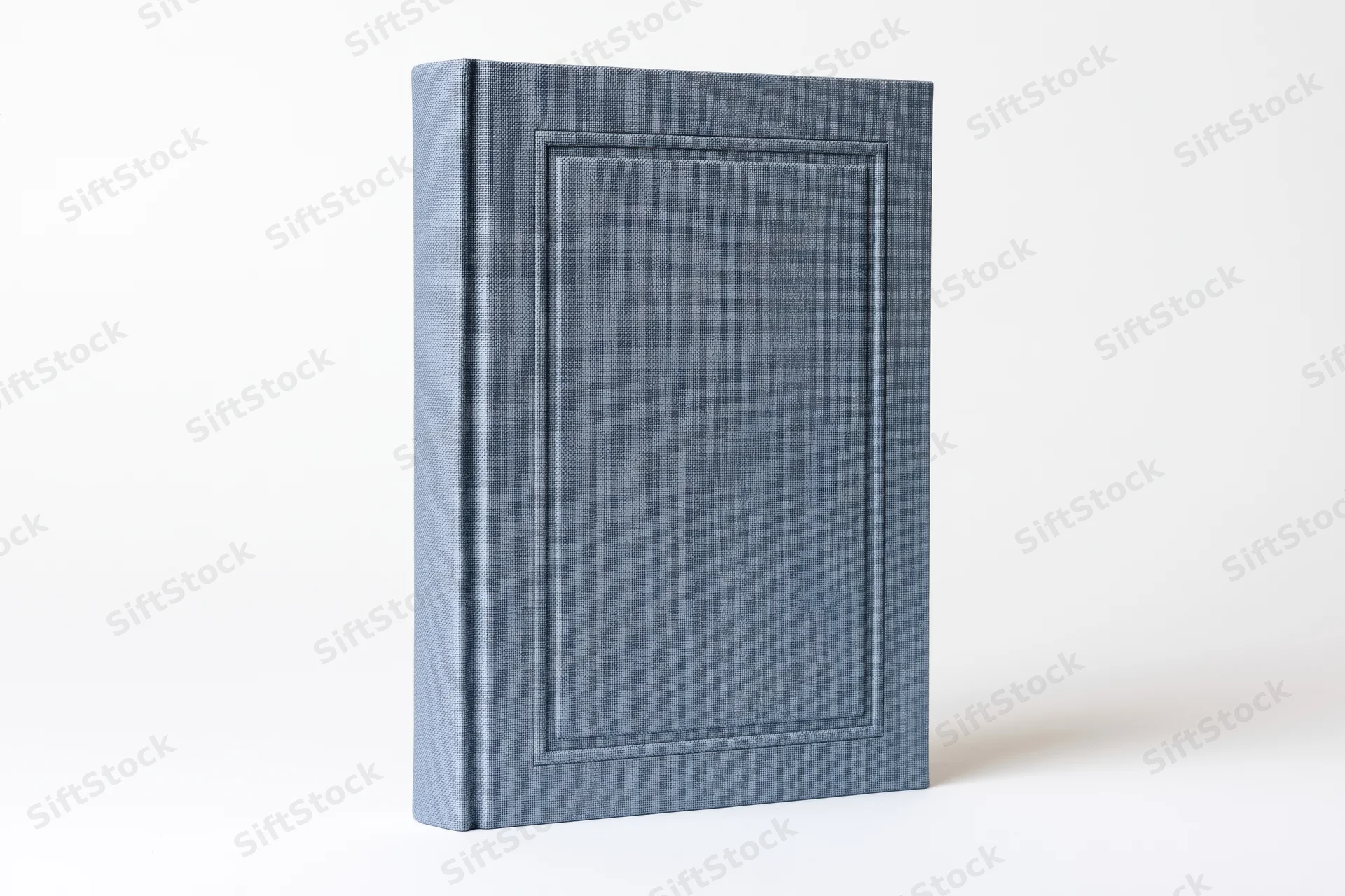 Blank hardcover book with textured slate-blue cloth cover standing upright on white background