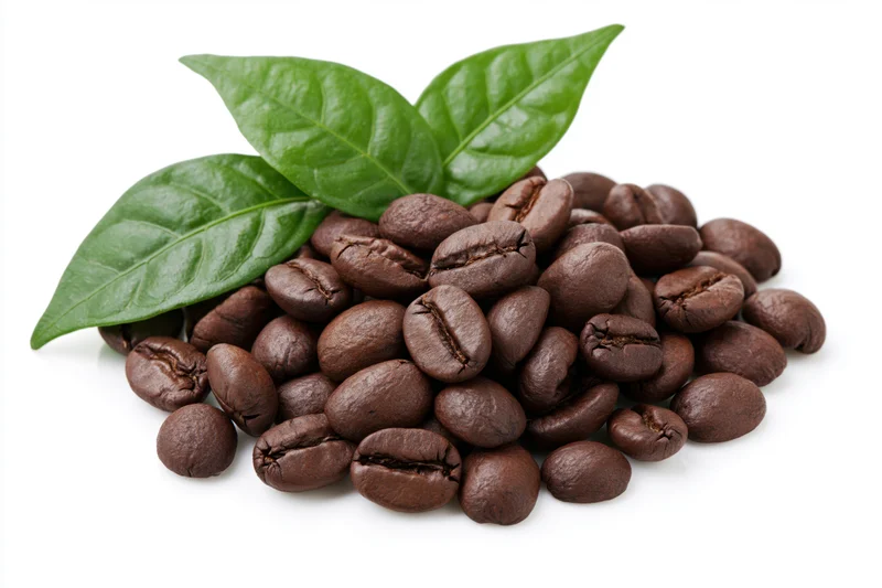 Roasted coffee beans piled with green leaves on white background