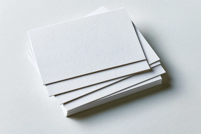 Stack of blank white business cards fanned on a plain surface