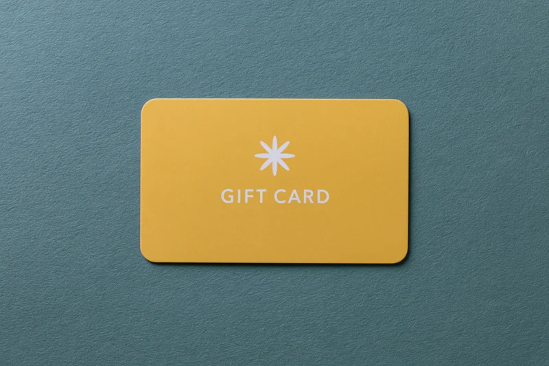 Yellow gift card lying flat on textured teal surface
