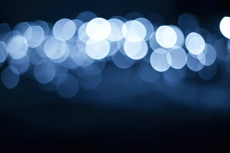 Blurred circular lights in blue tones against dark background