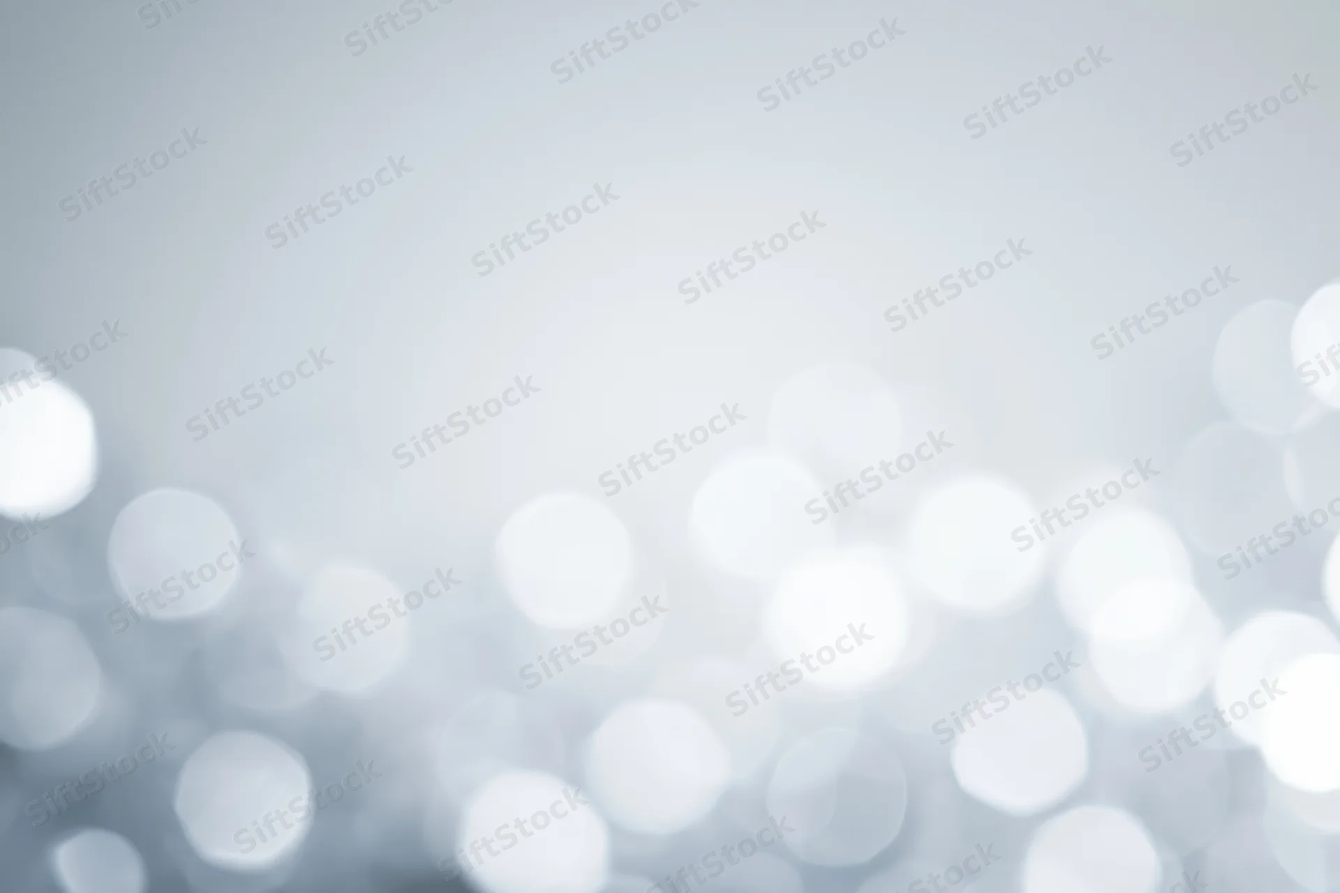 Abstract defocused background with scattered circular bokeh lights in white and gray tones