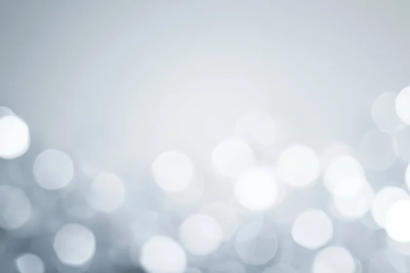 Abstract defocused background with scattered circular bokeh lights in white and gray tones